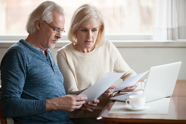 Serious-worried-senior-couple-calculating-bills-to-pay-or-checking-domestic-finances